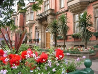 a photograph of Hyde Town Hall with flowers in the foreground