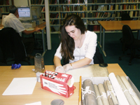Photograph of one of our volunteers handling archive material