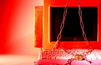 photograph of a computer with a padlock and chain