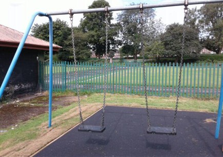 Two flat swings situated on wetpour