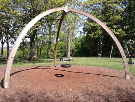 Chained tire swing situated on play bark