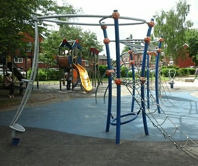 Climbing Frame, metal climbing apparatus with climbing ropes, spinning pole and monkey bars situated on wetpour