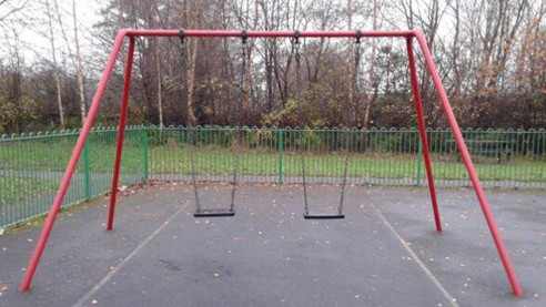 Two flat seat swings situated on wetpour