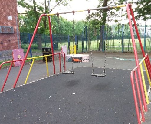 Two flat seat swings situated on wetpour