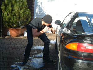 Image of a thief breaking into a car