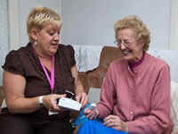 Member of staff showing deaf lady some equipment