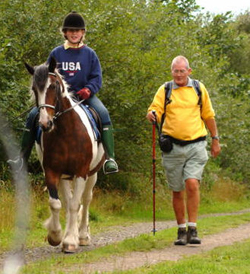 Image of a girl riding a horse on a bridleway