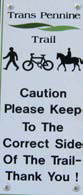 Image of the Trans Pennine Trail sign saying 'Caution Please Keep To The Correct Side Of The Trail - Thank you !'