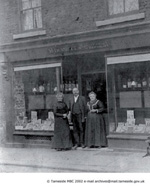 Old image of a family stood in front of a shop