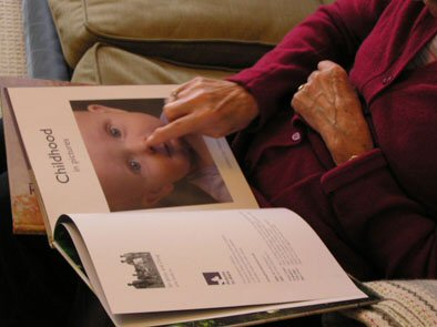 a picture of someone looking at the book Childhood in pictures